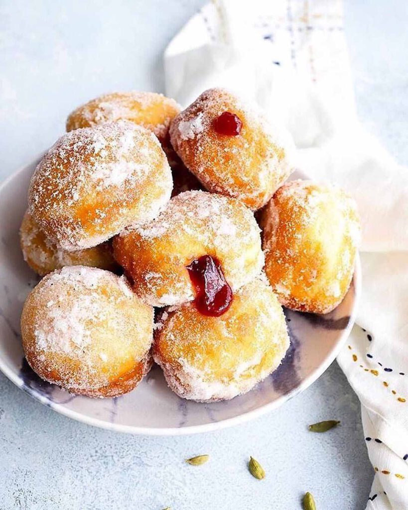 Vegan Raspberry Jam Doughnuts With Cardamom Sugar recipe served on a plate.