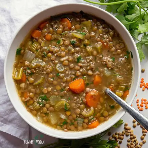 Easy Vegan Lentil Soup recipe served in a bowl with spoon.