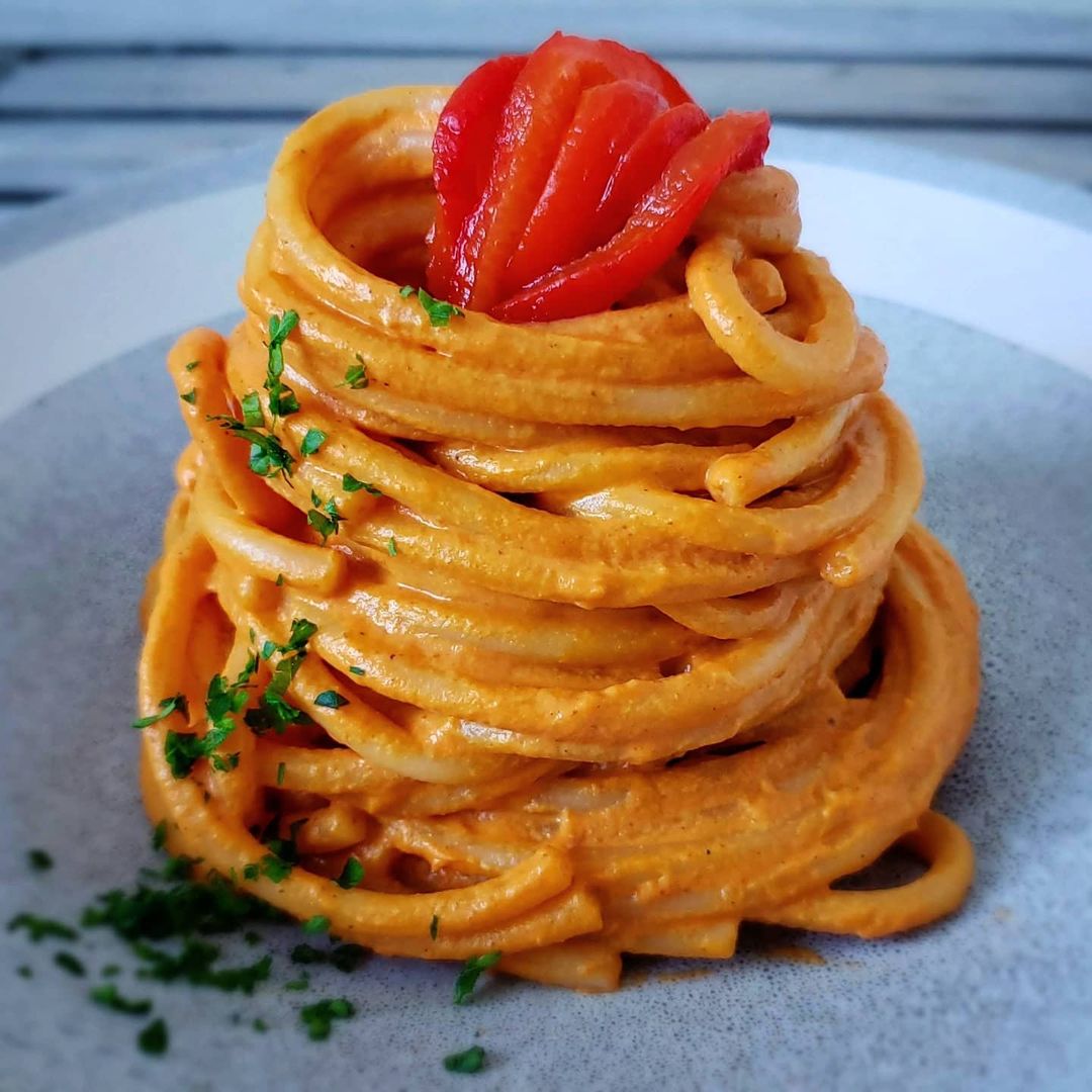 Bucatini With Creamy Roasted Red Bell Pepper & Harissa Sauce recipe served on a plate.
