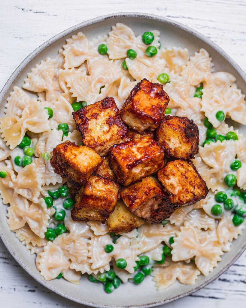 Creamy Coconut Pasta with Crispy Tofu recipe displayed in a bowl.