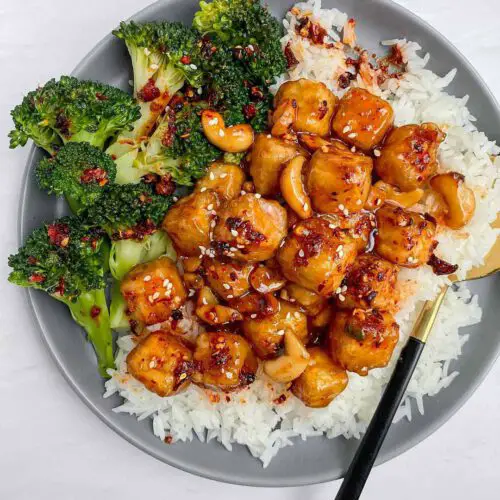 Sticky Cashew Tofu recipe served on a plate with rice and broccoli.