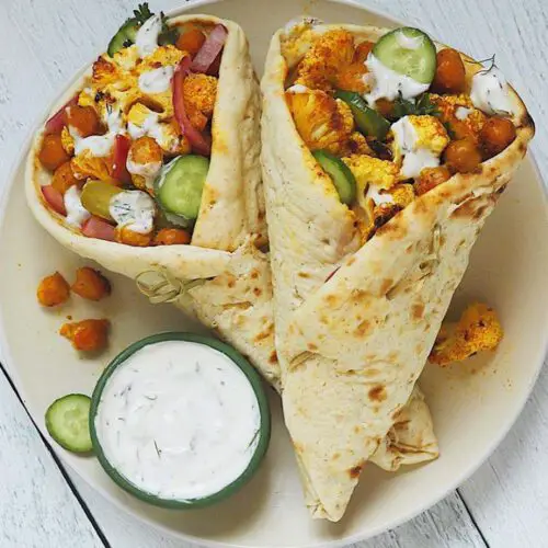 Roasted Cauliflower & Chickpea Shawarma Wrap recipe served on a plate with dip.