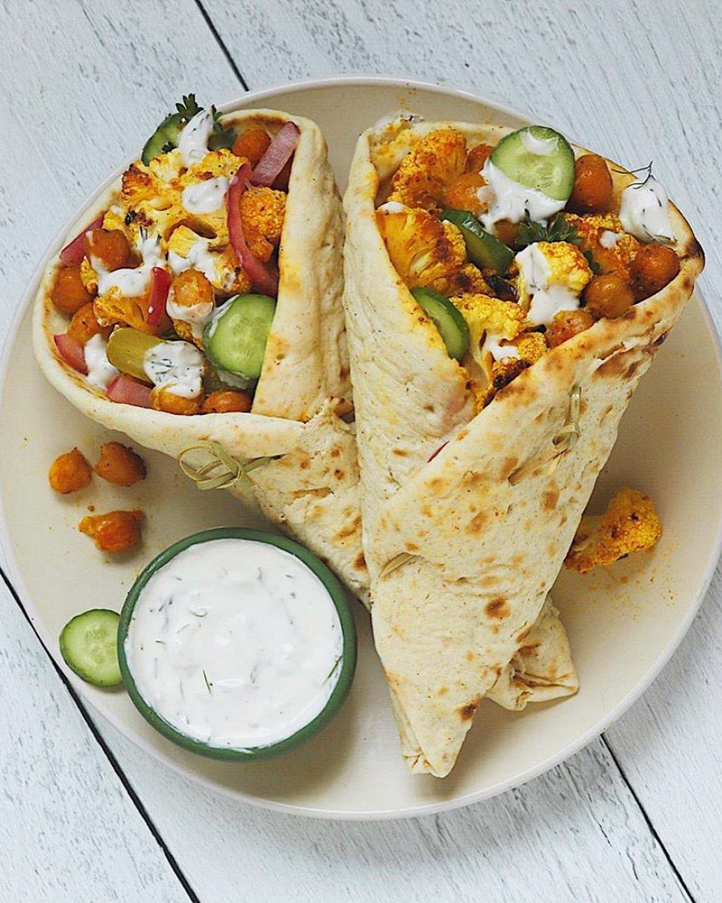 Roasted Cauliflower & Chickpea Shawarma Wrap recipe served on a plate with dip.