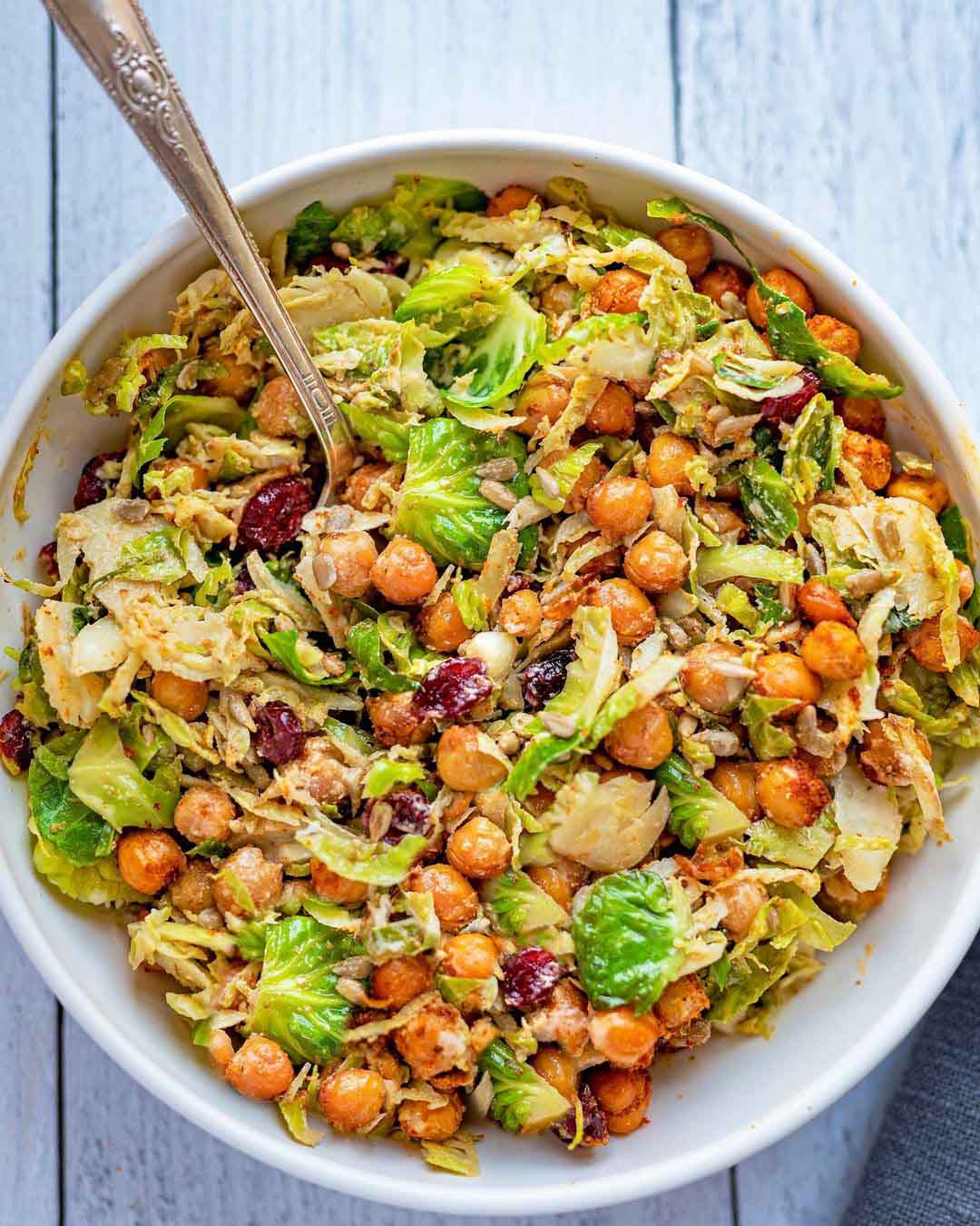 Chickpea & Brussels Vegan Caesar Salad served in a large bowl with spoon.