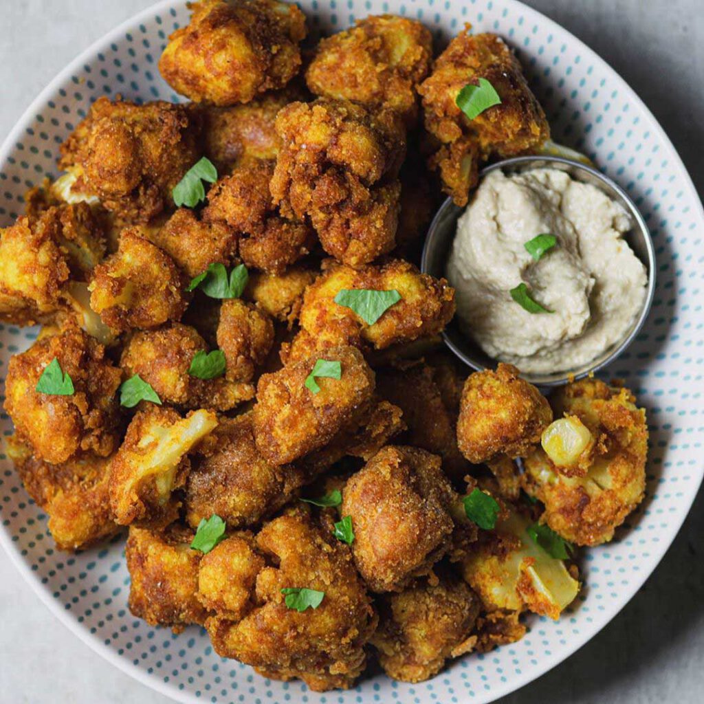 Crunchy Rice Flour Cauliflower Wings recipe served in a bowl with yogurt dip.