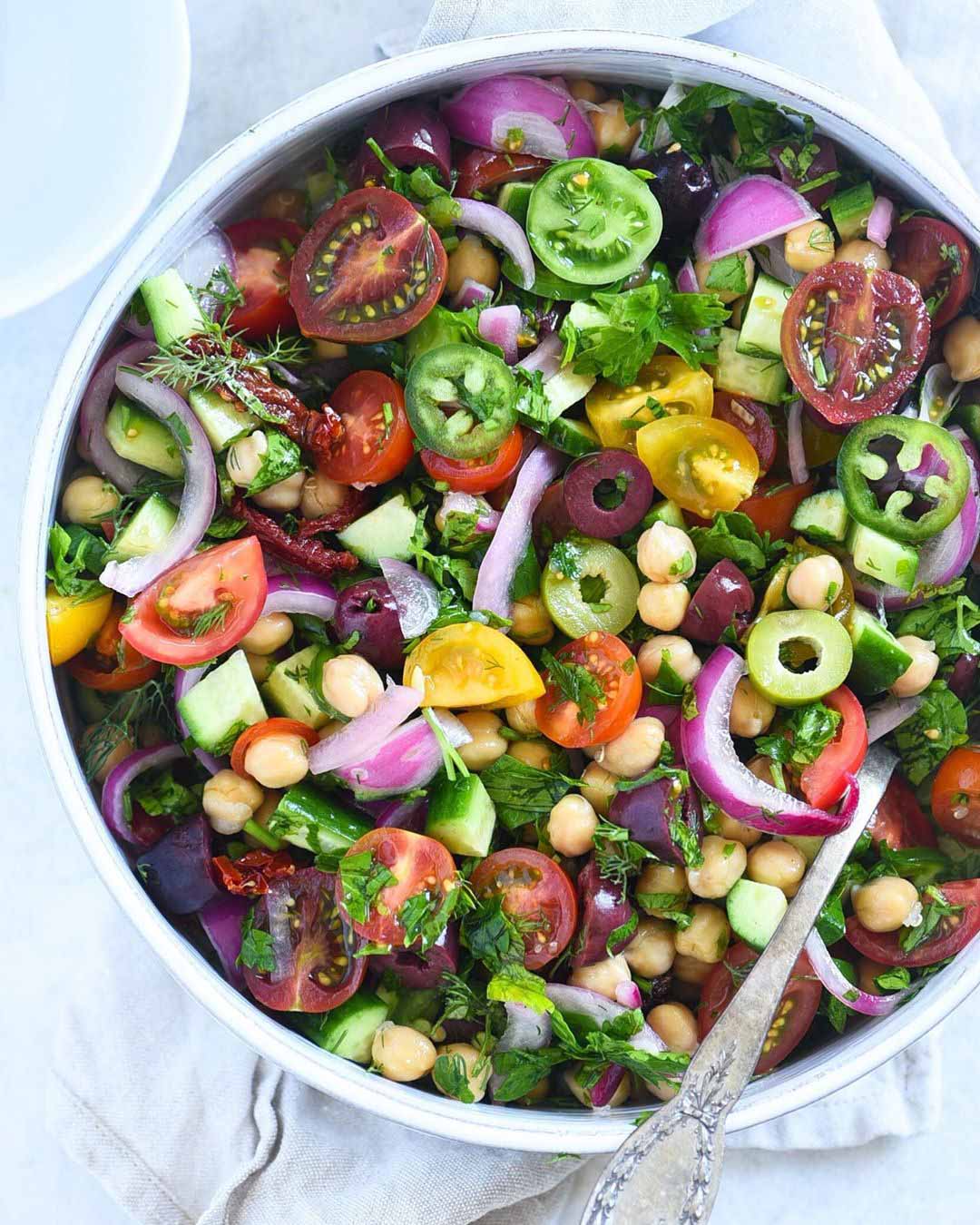 Mediterranean Chickpea Salad served in a large bowl with spoon.