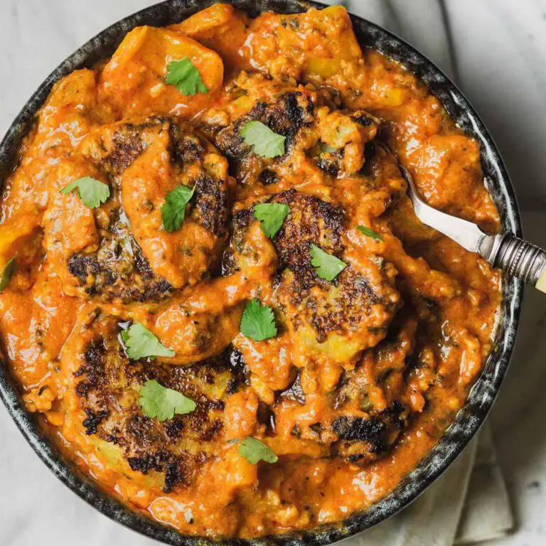 Smashed Potato Tikka Masala recipe displayed in a bowl with a spoon.