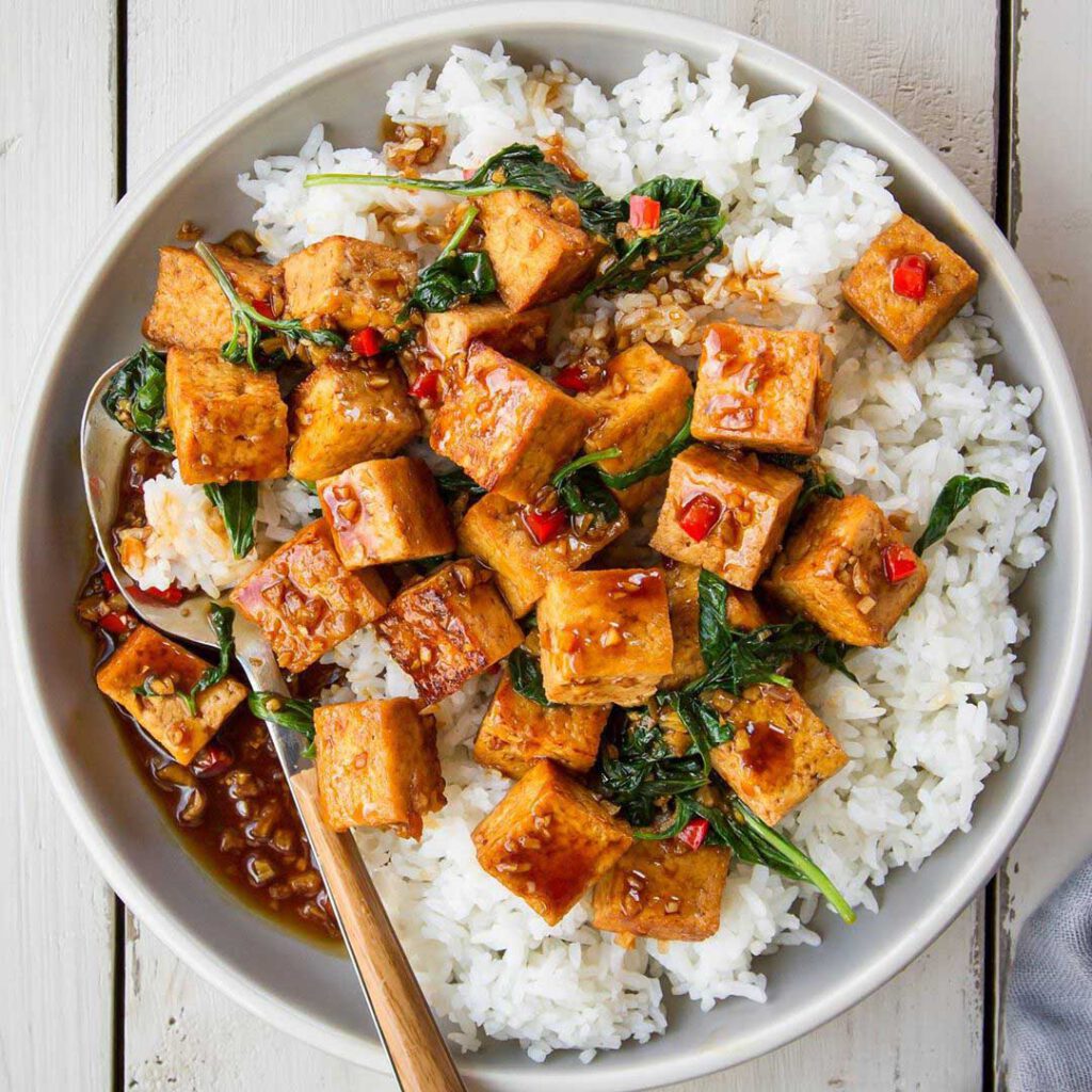 Thai Basil Chili Tofu recipe displayed in a bowl with chopsticks.