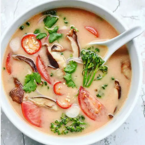 Vegan Tom Yum Soup recipe displayed in a bowl with spoon.