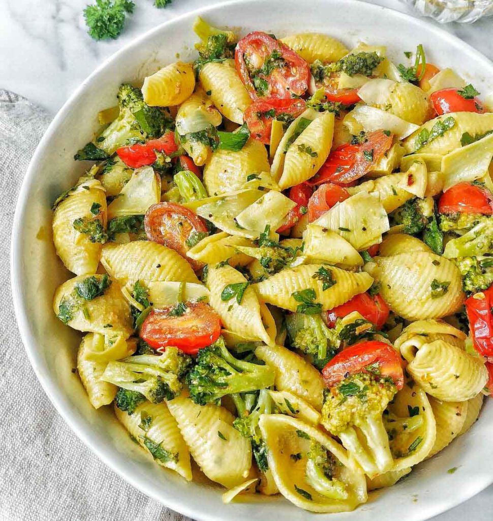 Vegan Cheesy Pasta With Broccoli & Tomatoes recipe served in a bowl.