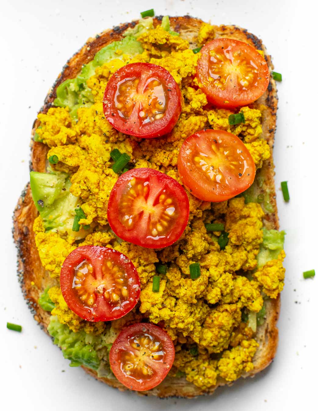10-Minute Tofu Scramble recipe served on toast with tomatoes.