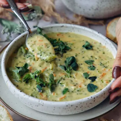 Vegan Broccoli Cheddar Soup recipe served in a bowl with spoon.